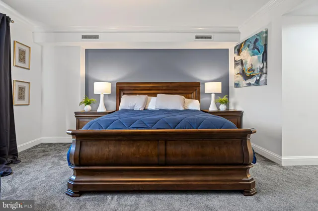 a bedroom with a bed and painting on the wall