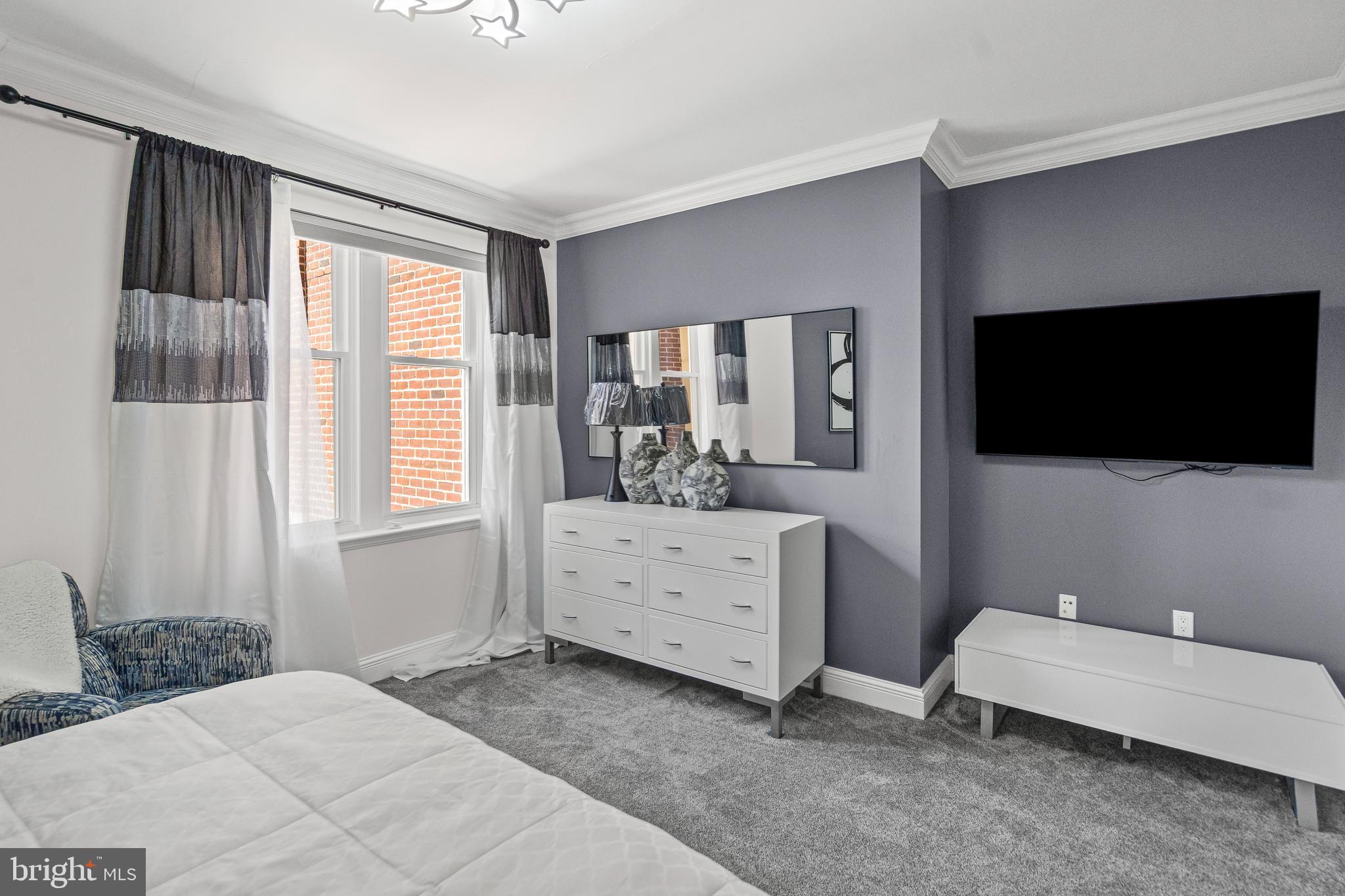 801 Key Highway, Unit 345 Baltimore, MD 21230 - Photo 31 of 57 a bedroom with a bed and a flat screen tv