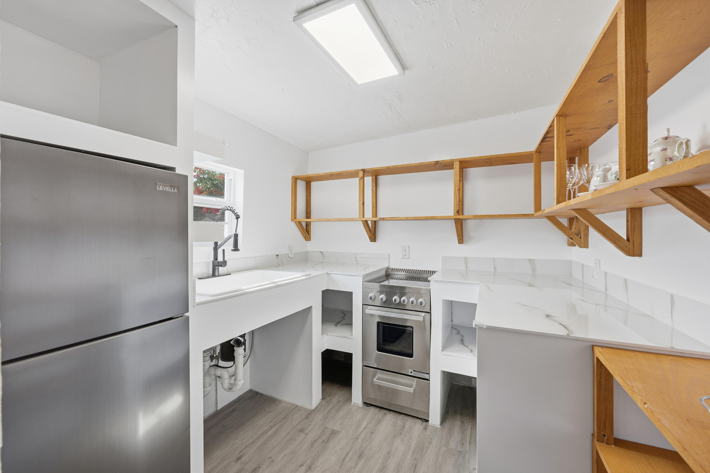 308 Southwest 1st Street Delray Beach, FL 33444 - Photo 9 of 26 a kitchen with stainless steel appliances a stove a sink and a refrigerator