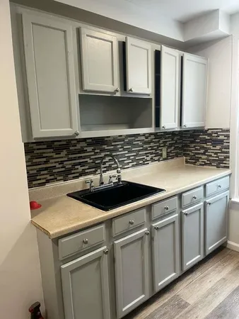a view of a kitchen with sink and cabinets