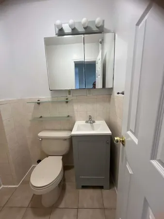 a bathroom with a toilet sink and mirror