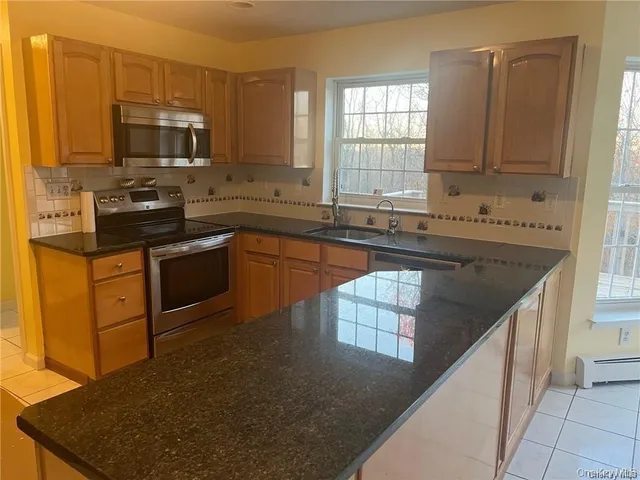 a kitchen with stainless steel appliances granite countertop a sink stove and microwave