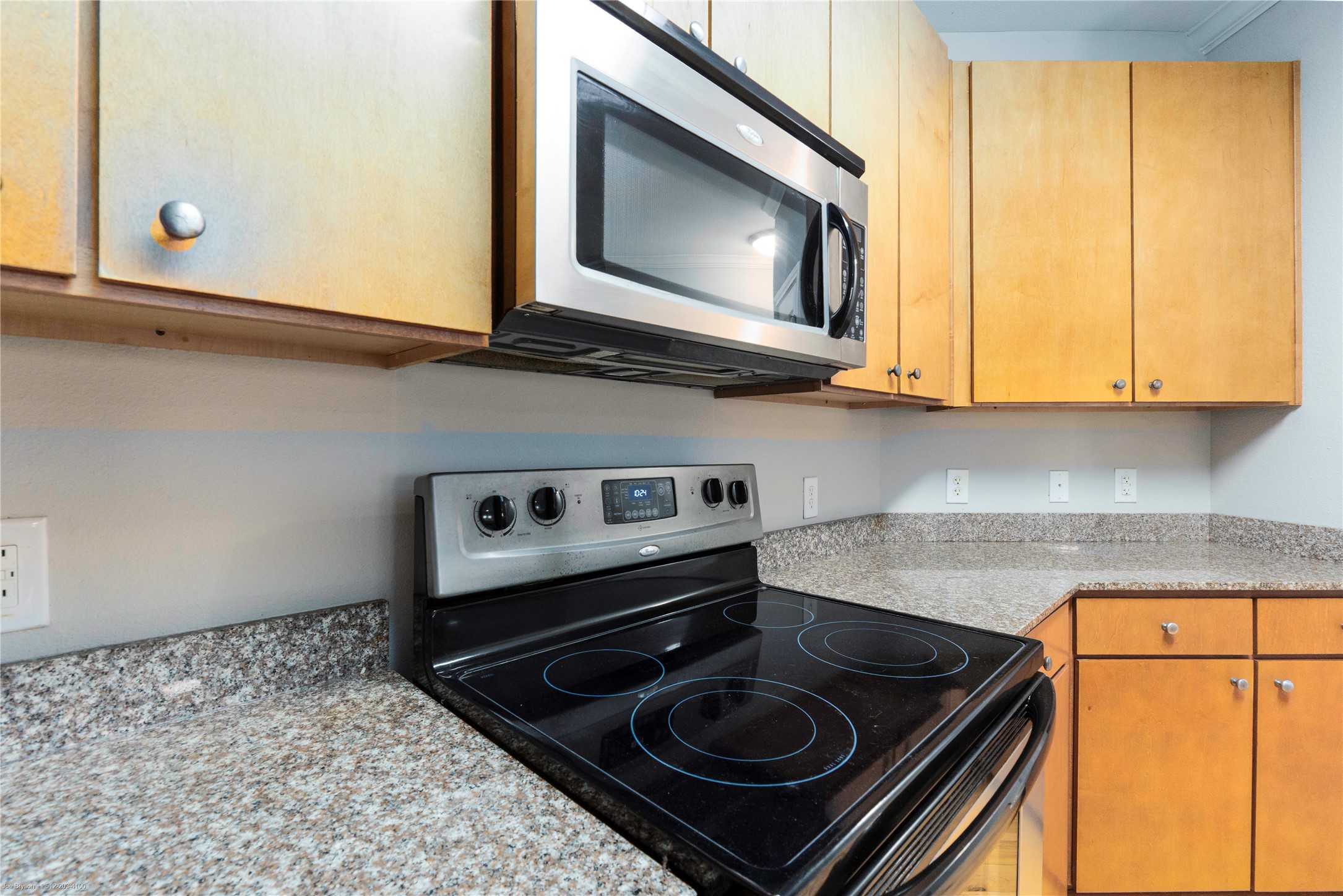 2502 Leon Street, Unit 305 Austin, TX 78705 - Photo 10 of 26 Kitchen with range with electric cooktop, stainless steel microwave, and light countertops