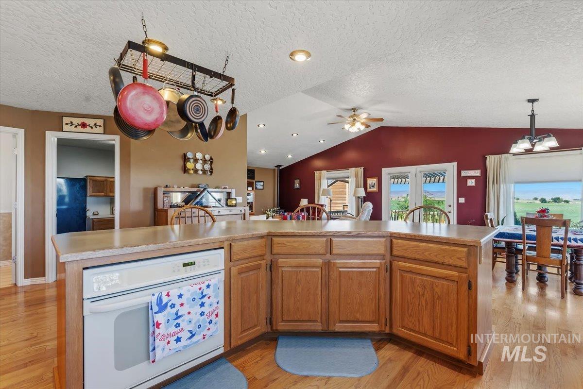 2331 Gulley Road Homedale, ID 83628 - Photo 15 of 46 Kitchen island featuring wood-finish cabinetry, a built-in oven, and overhead pot rack