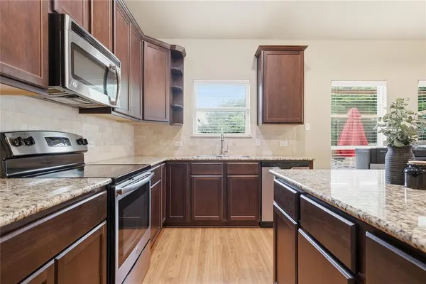 a kitchen with stainless steel appliances granite countertop a sink stove and cabinets