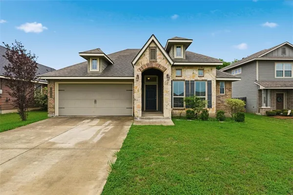 a front view of a house with a yard and garage