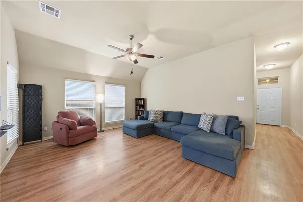 a living room with furniture and a wooden floor