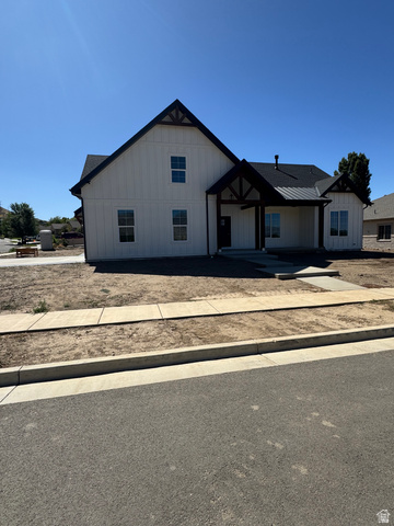 389 West 2100 South Perry, UT 84302 - Photo 8 of 21 White board and batten exterior with dark trim accents, covered entry, and dark asphalt shingle roof
