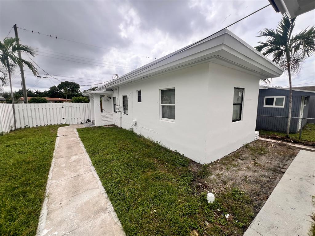 612 Northwest 6th Court, Unit 1 Hallandale Beach, FL 33009 - Photo 2 of 3 a front view of a house with a yard and potted plants