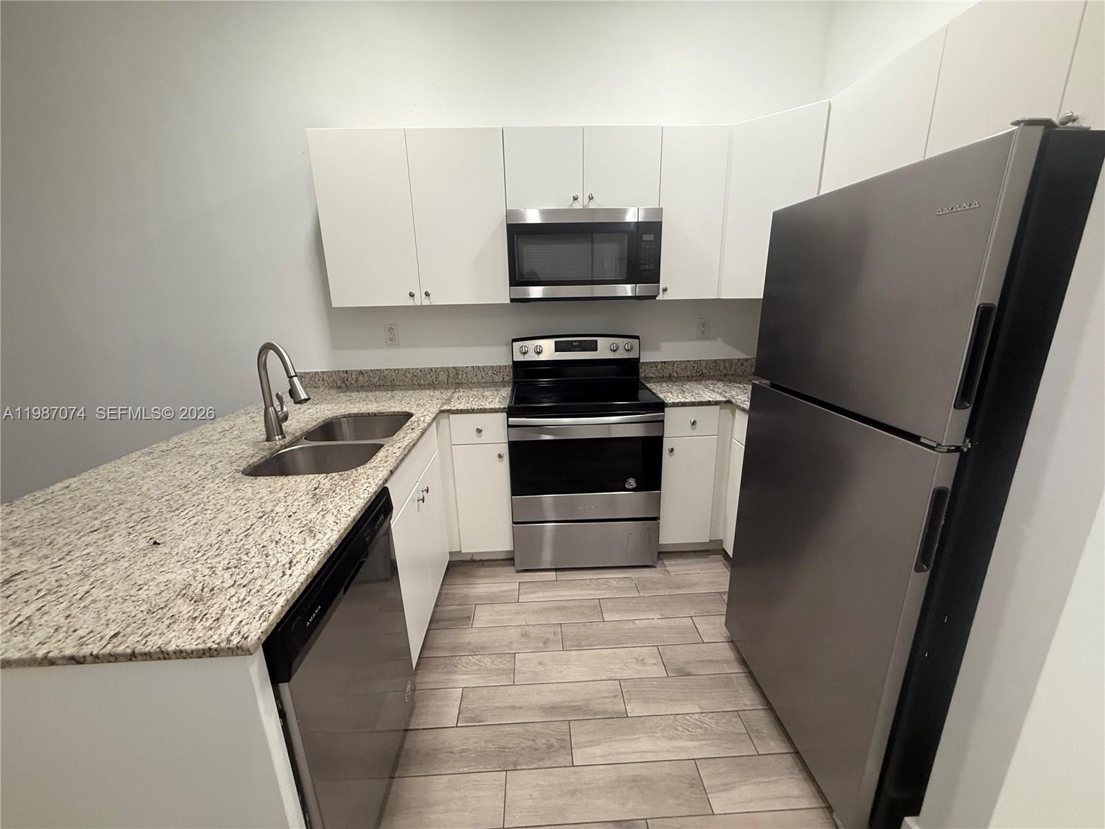 486 East 30th Street, Unit 202 Hialeah, FL 33013 - Photo 15 of 16 a kitchen with granite countertop a refrigerator and a sink
