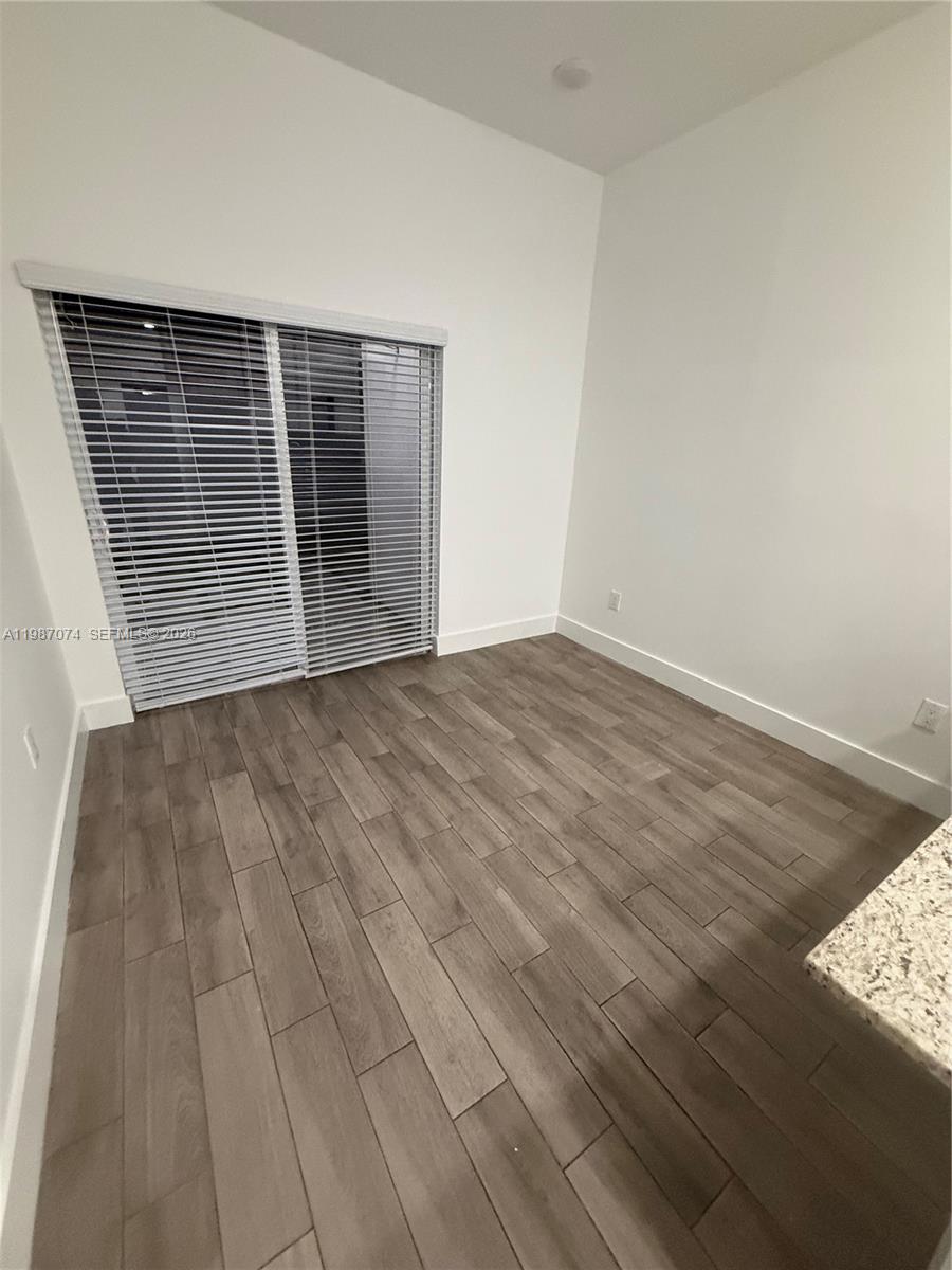 486 East 30th Street, Unit 202 Hialeah, FL 33013 - Photo 16 of 16 a view of an empty room with wooden floor and a window