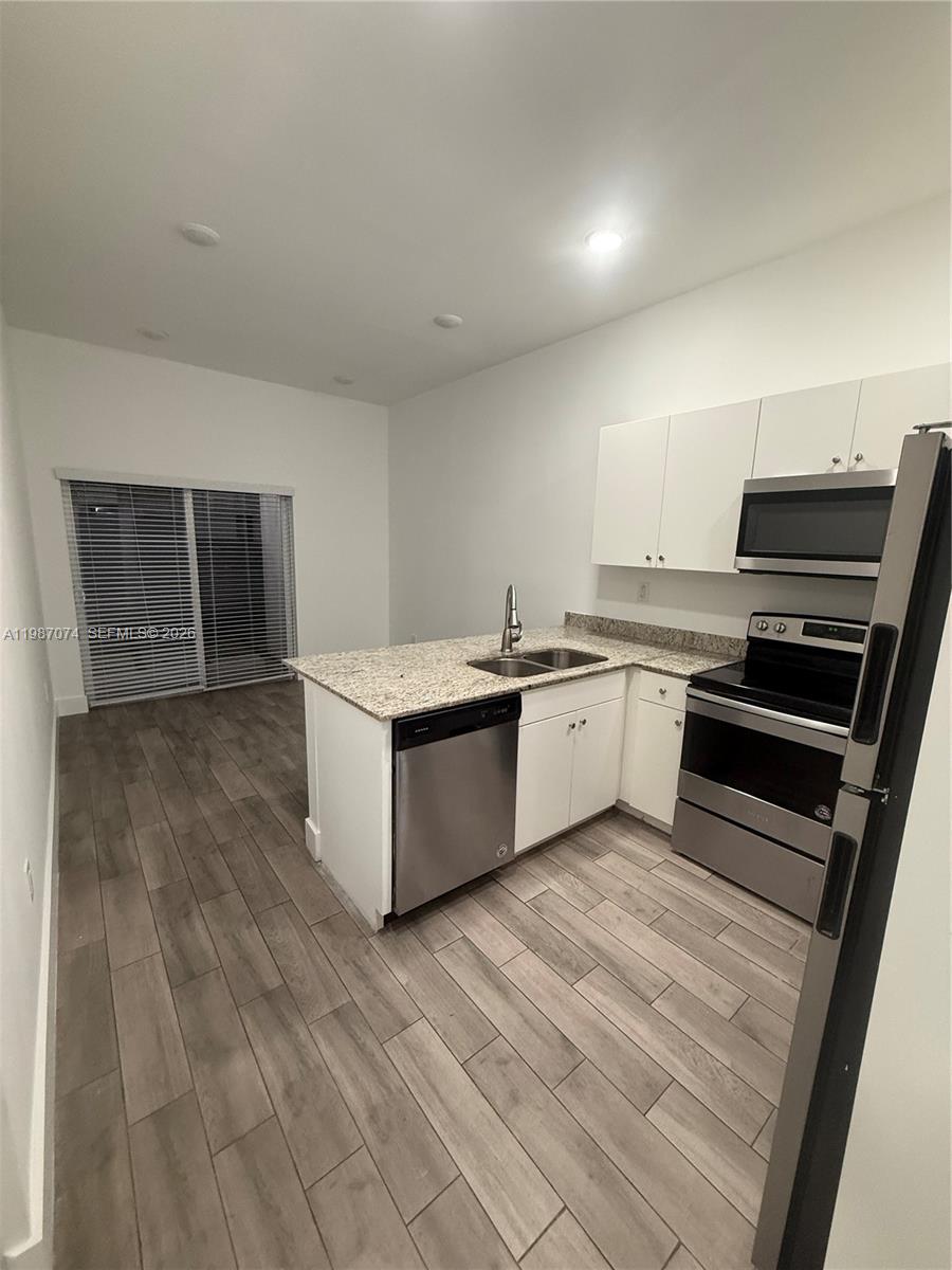 486 East 30th Street, Unit 202 Hialeah, FL 33013 - Photo 4 of 16 a view of kitchen with wooden floor and electronic appliances