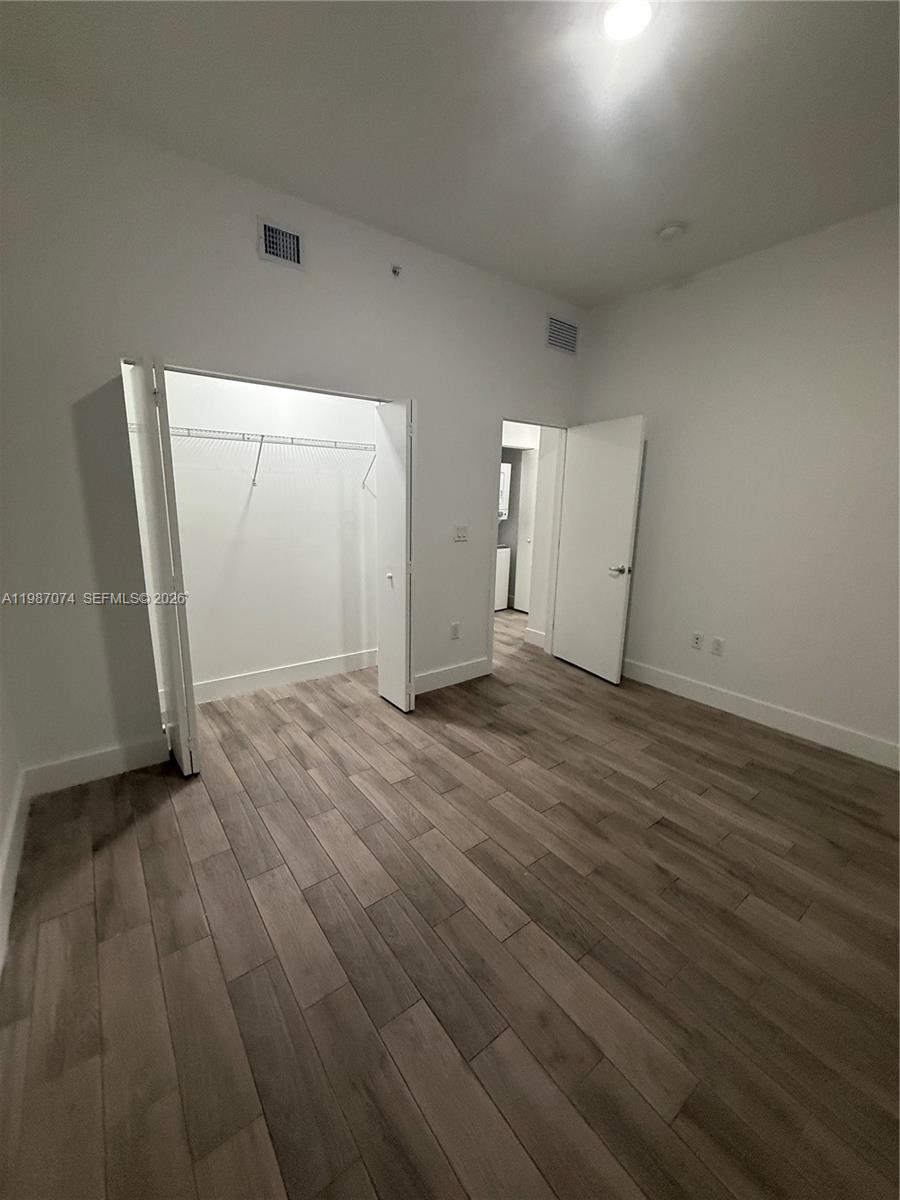 486 East 30th Street, Unit 202 Hialeah, FL 33013 - Photo 9 of 16 an empty room with wooden floor and windows