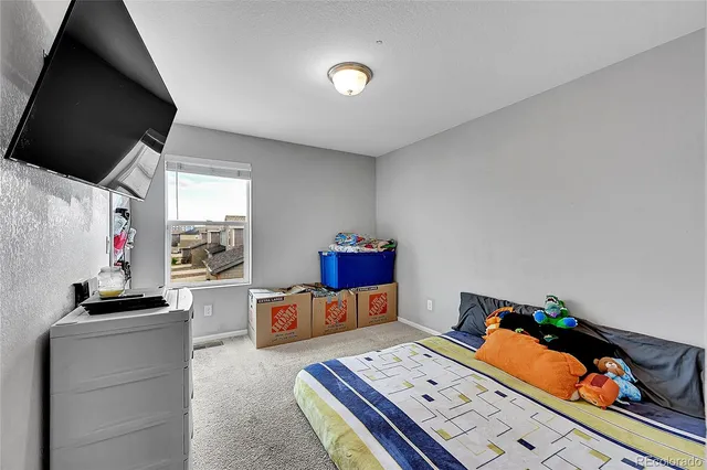 a bedroom with furniture and a flat screen tv