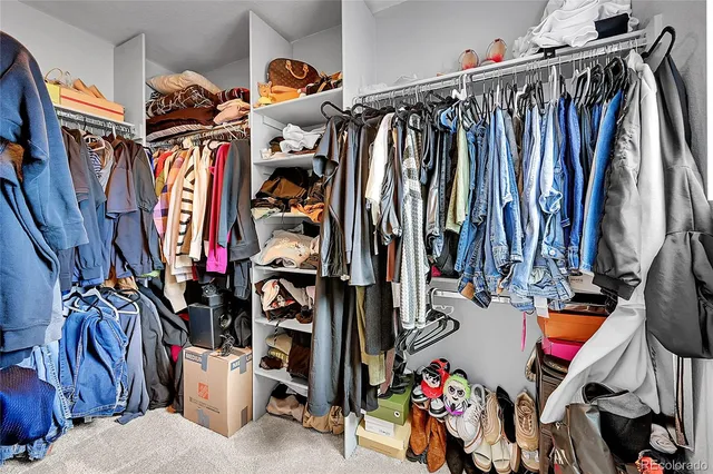 a view of walk in closet with clothes