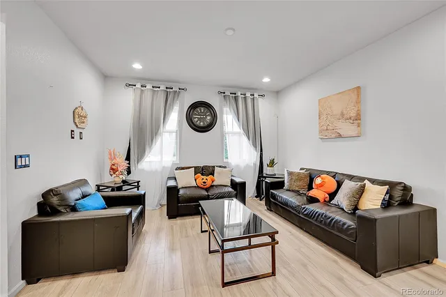 a living room with furniture and a wooden floor