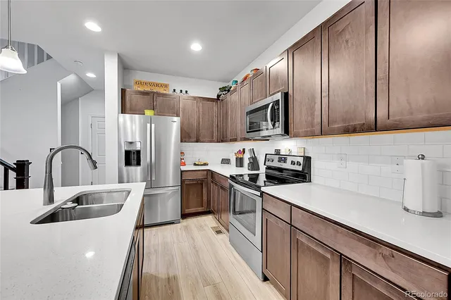a kitchen with stainless steel appliances granite countertop a sink refrigerator and cabinets