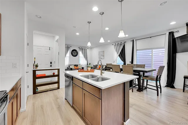 a large kitchen with a stove a sink a dining table and chairs