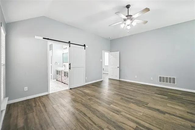 a view of an empty room with wooden floor