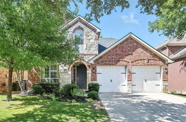 a front view of a house with a garden and plants