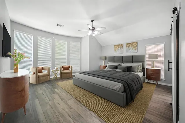 a large bedroom with a large bed and a chandelier