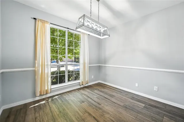en empty room with wooden floor and windows