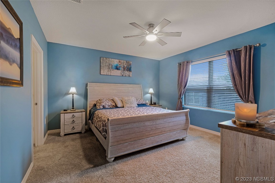 354 Camilla Road DeLand, FL 32724 - Photo 17 of 57 a bedroom with a bed and a chandelier