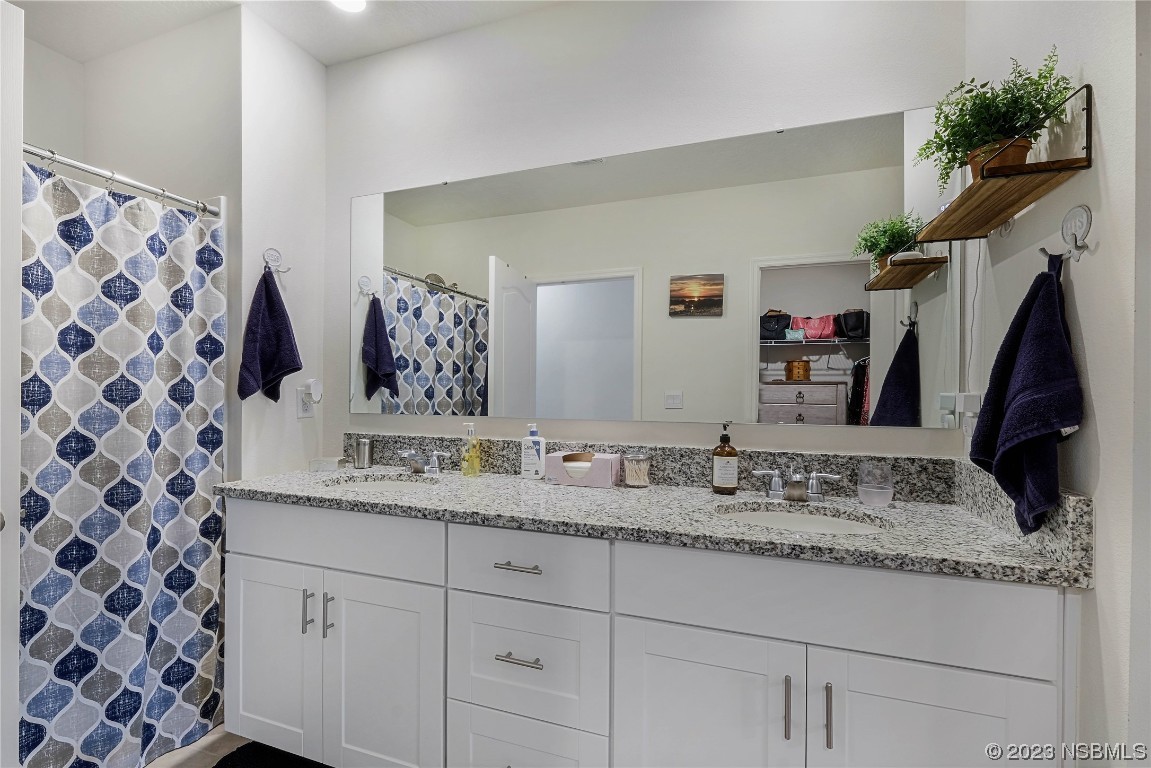 354 Camilla Road DeLand, FL 32724 - Photo 22 of 57 a bathroom with a granite countertop sink a mirror and shower