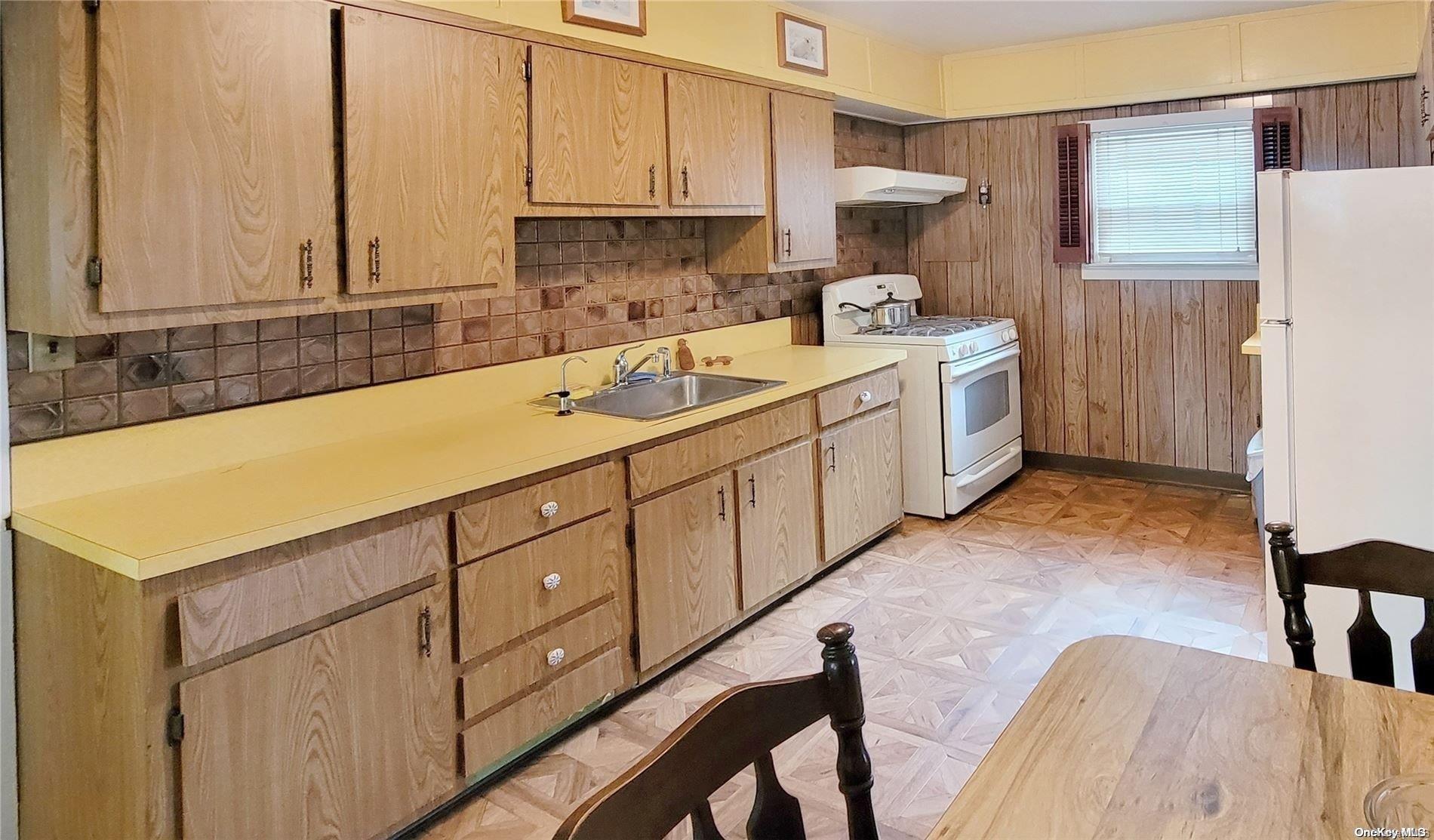 138 Hewlett Avenue Merrick, NY 11566 - Photo 13 of 35 a kitchen with a sink a stove and cabinets