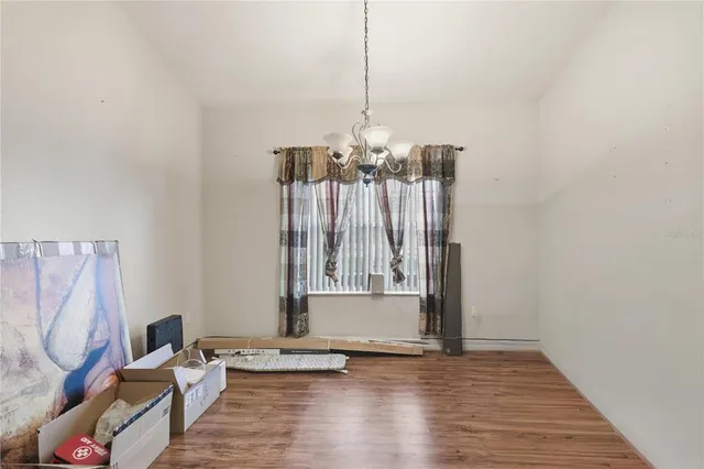 a view of a room with wooden floor table and chairs