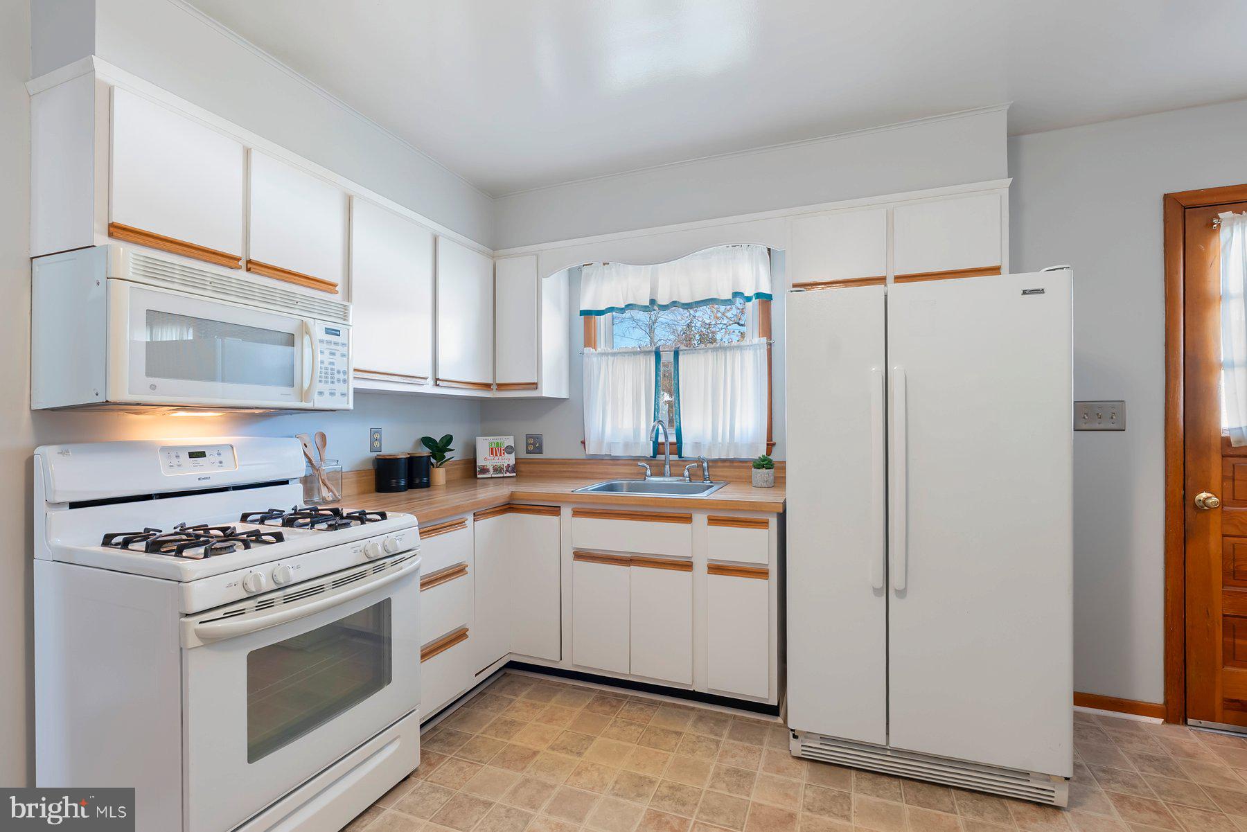 8301 Overmont Road Baltimore, MD 21234 - Photo 11 of 28 a kitchen with white cabinets and white appliances