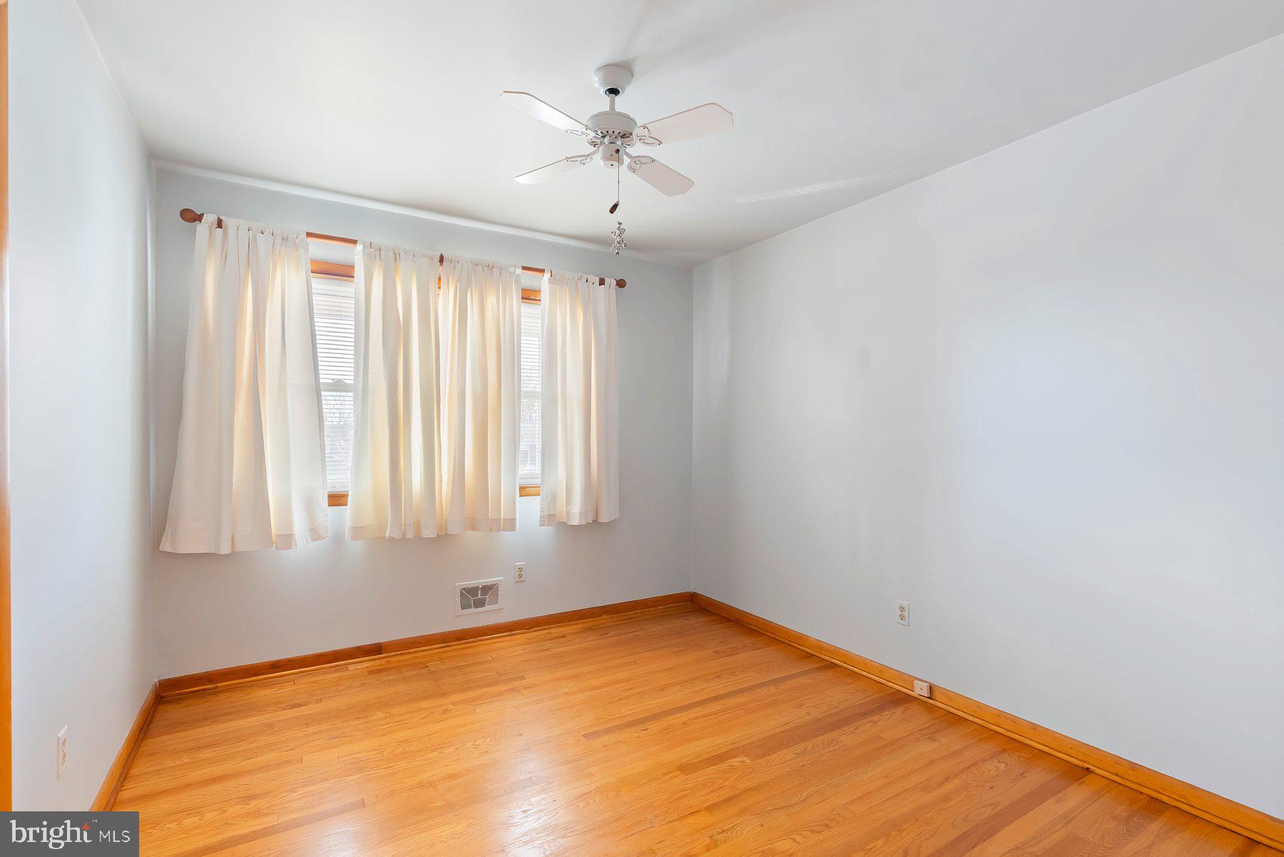 8301 Overmont Road Baltimore, MD 21234 - Photo 16 of 28 an empty room with a window and a ceiling fan