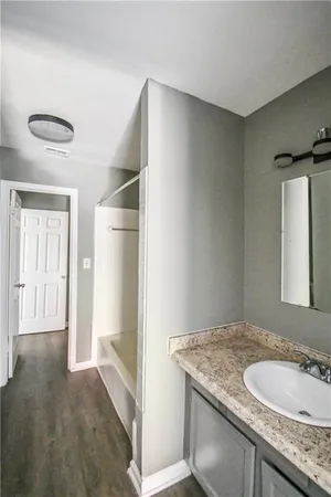 a bathroom with a granite countertop sink and a mirror