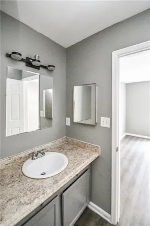 a bathroom with a granite countertop sink and a mirror