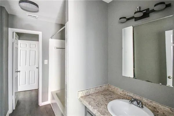 a bathroom with a granite countertop sink and a mirror