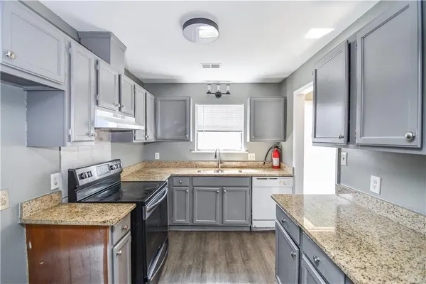 a kitchen with a sink stove top oven and cabinets