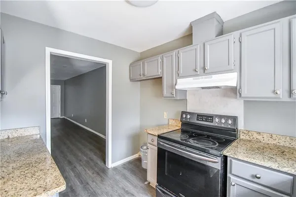 a kitchen with white cabinets and appliances
