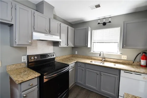 a kitchen with a sink stove and cabinets