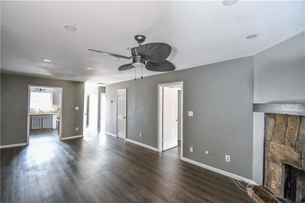 a view of a room with wooden floor and a ceiling fan