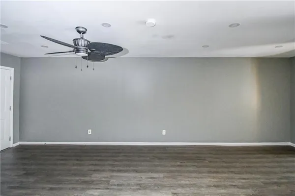 a view of a room with wooden floor and ceiling fan