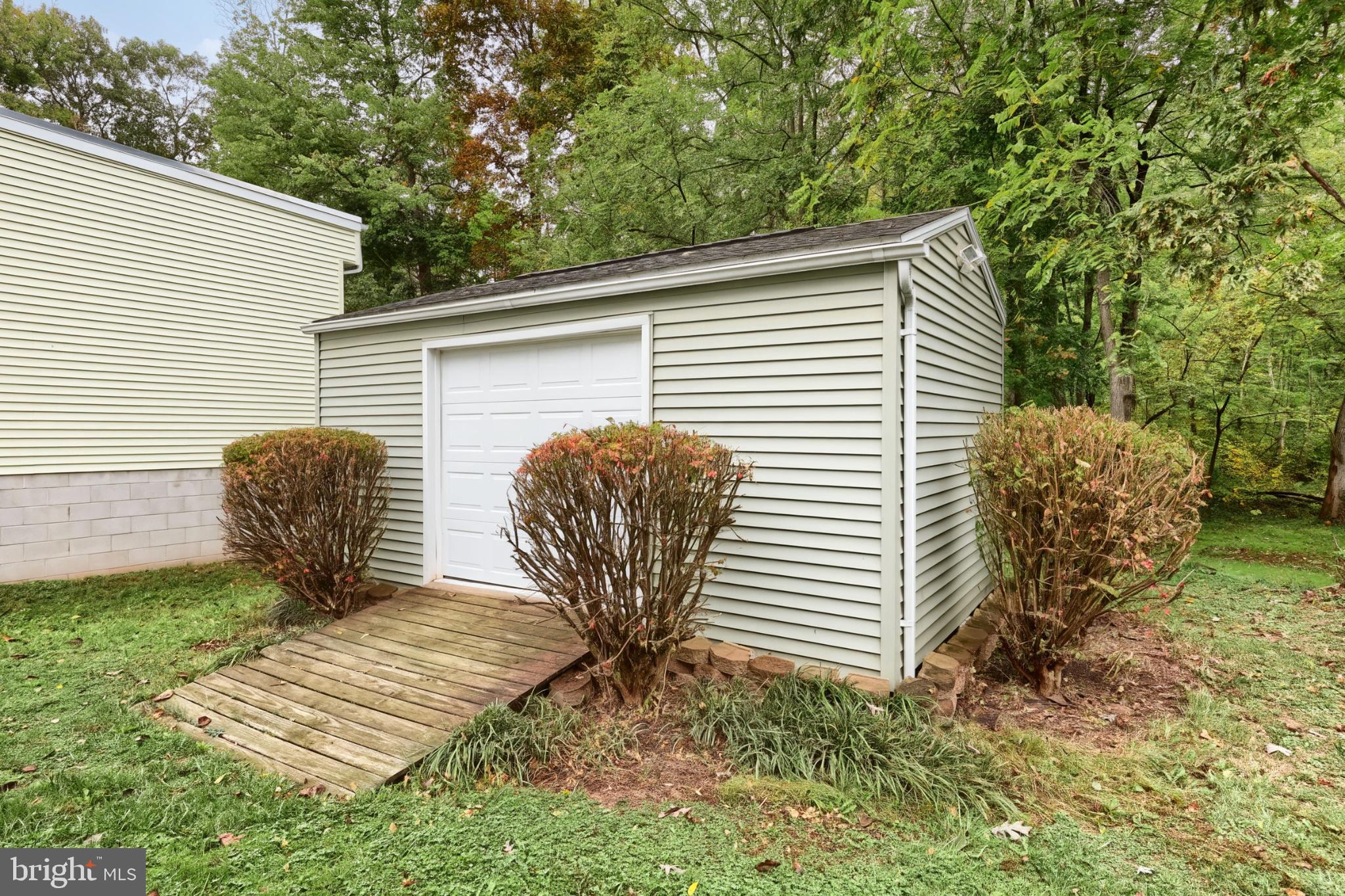 4105 Smith Road Dover, PA 17315 - Photo 8 of 28 Charming shed nestled in lush greenery.