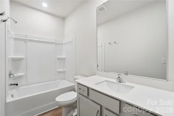 a bathroom with a sink toilet vanity granite tub and shower
