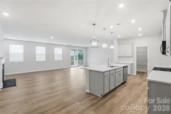 a large kitchen with stainless steel appliances granite countertop a lot of counter space and wooden floors