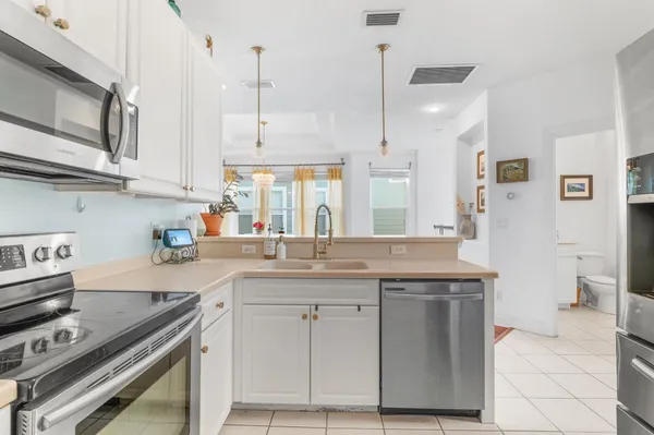a kitchen with stainless steel appliances granite countertop a stove a sink and a refrigerator