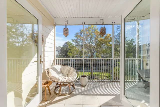 a balcony view with a glass top table and chairs