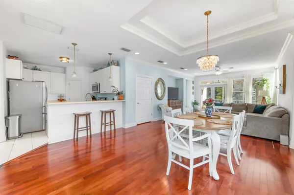 a view of a dining room and livingroom with furniture wooden floor a chandelier