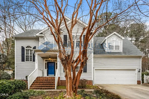 a front view of a house with a tree