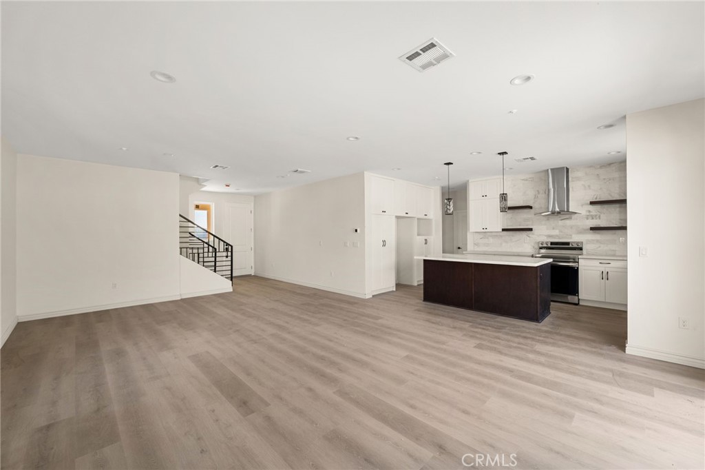3260 Howe Street Corona, CA 92881 - Photo 9 of 28 a large kitchen with cabinets and wooden floor