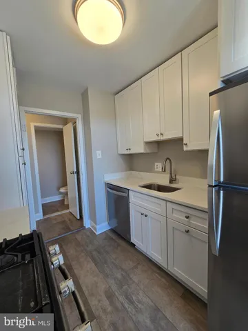 a kitchen with a refrigerator sink and cabinets