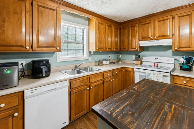 a bathroom with a granite countertop sink a mirror and shower